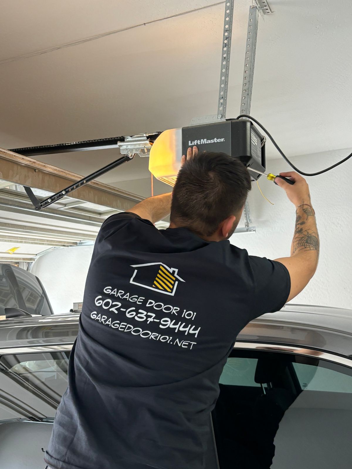 101 Garage Doors Repair technician servicing a LiftMaster garage door opener.