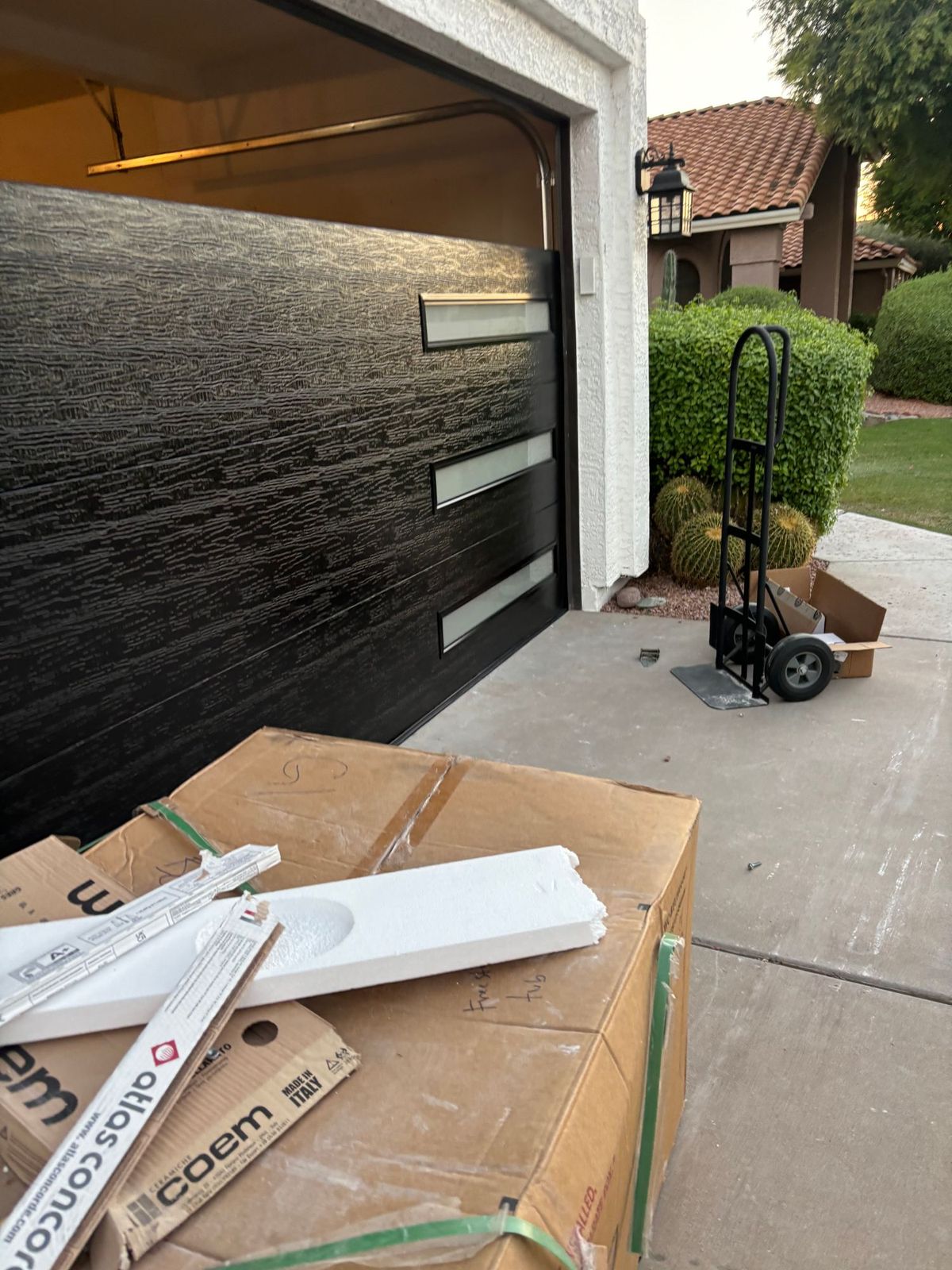 Black modern garage door installation in progress.