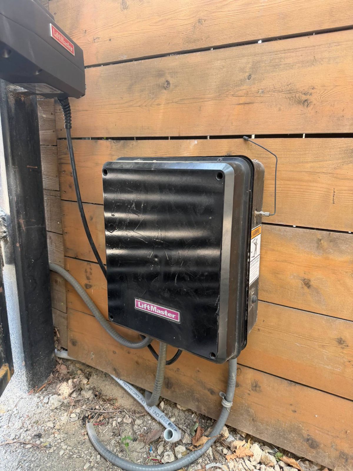 Gate operator control box mounted on a wood fence