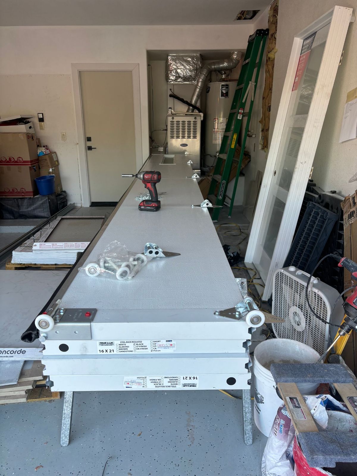 Insulated steel garage door sections being assembled before installation.